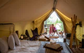 woman relaxing outside a glamping tent in Maine