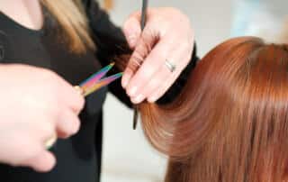 stylist trimming a client's hair at a salon in augusta maine
