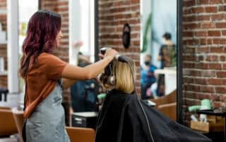 a stylist giving a haircut and style at a salon in bangor maine
